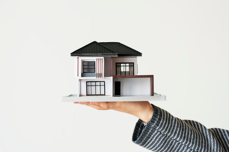 mano-que-presenta-casa-modelo-campana-prestamos-hipotecarios